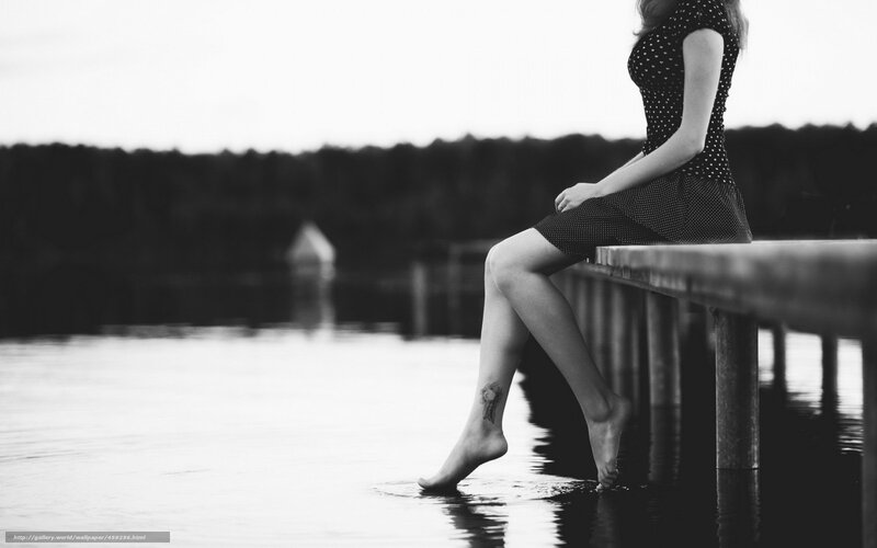 woman sitting on dock by water