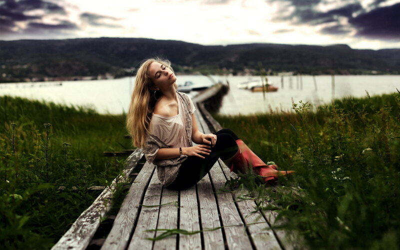 Woman Sitting on Dock — Green, Serene, Sunset