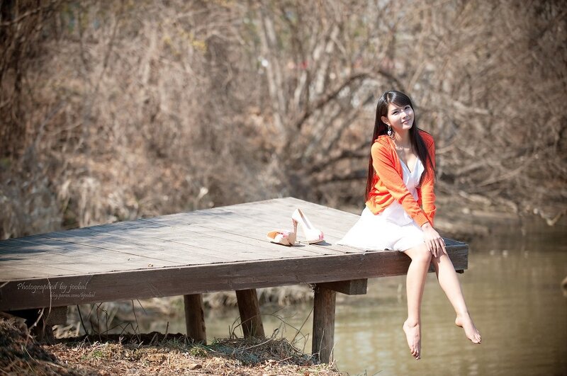 Woman Sitting on Dock — Orange, Serene, Spring