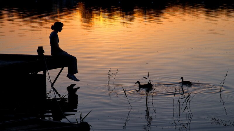 Woman Sitting on Dock — Orange, Serene, Sunset