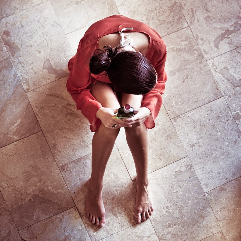 woman sitting on floor holding bottle