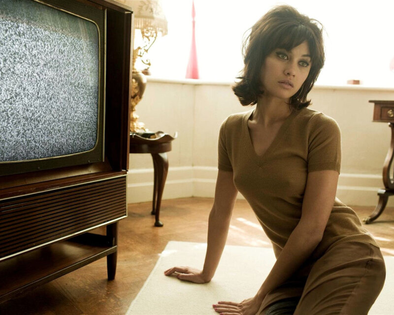 woman sitting on floor near vintage TV