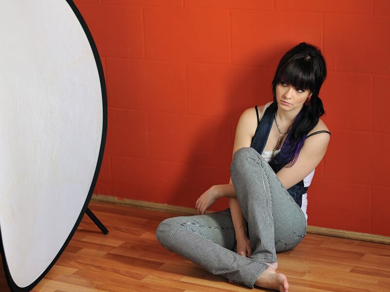 woman sitting on floor with reflector