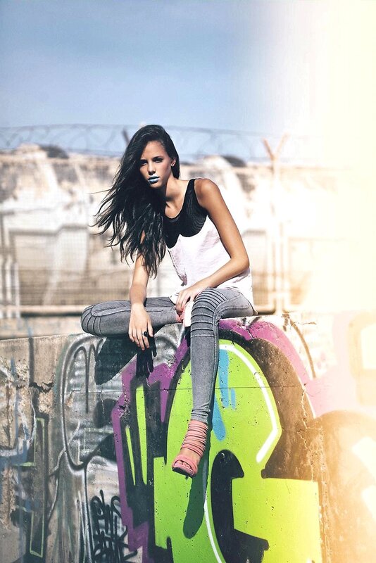 woman sitting on graffiti wall