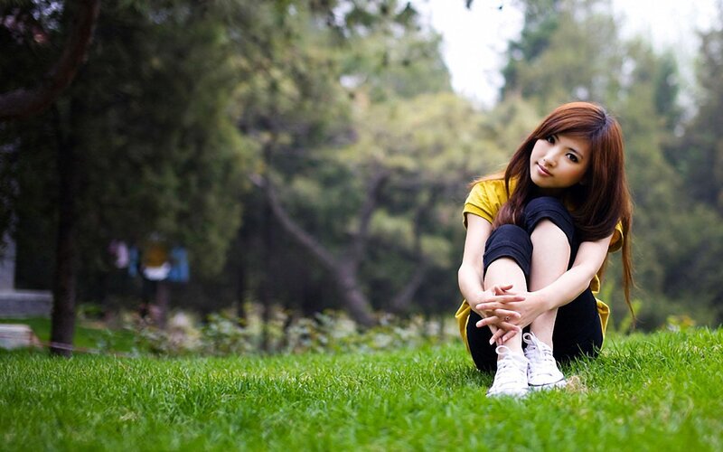 woman sitting on grass in park