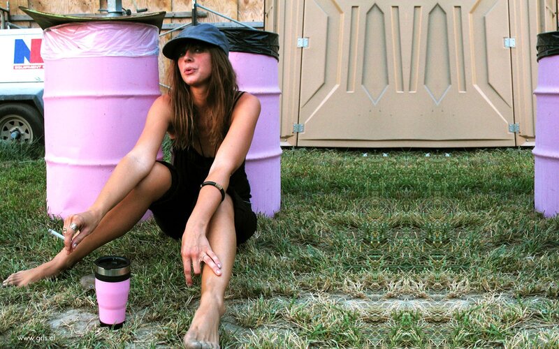 woman sitting on grass near barrels