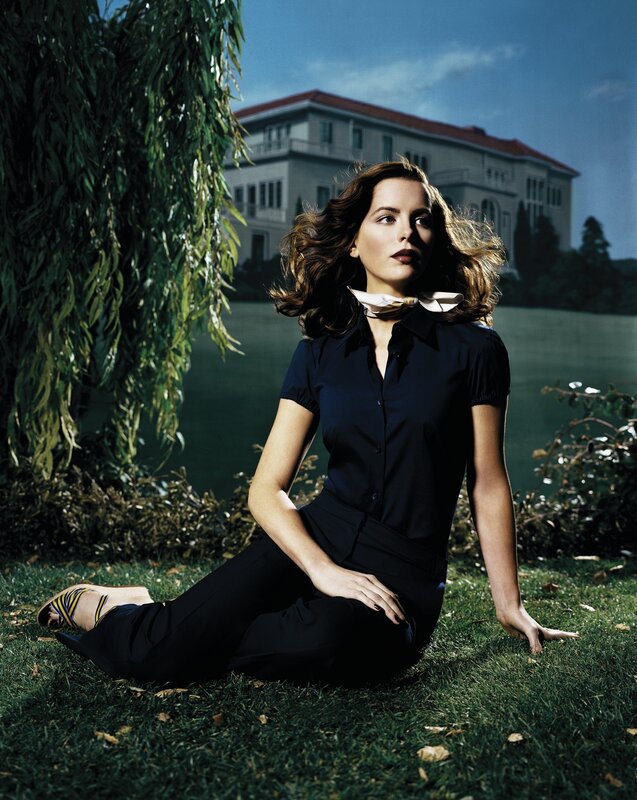 woman sitting on grass near house