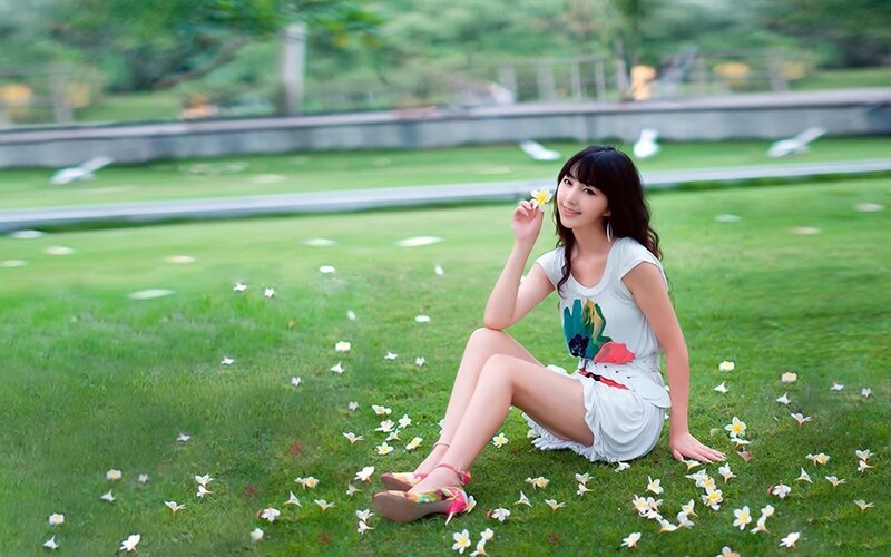 Woman sitting on grass with flowers