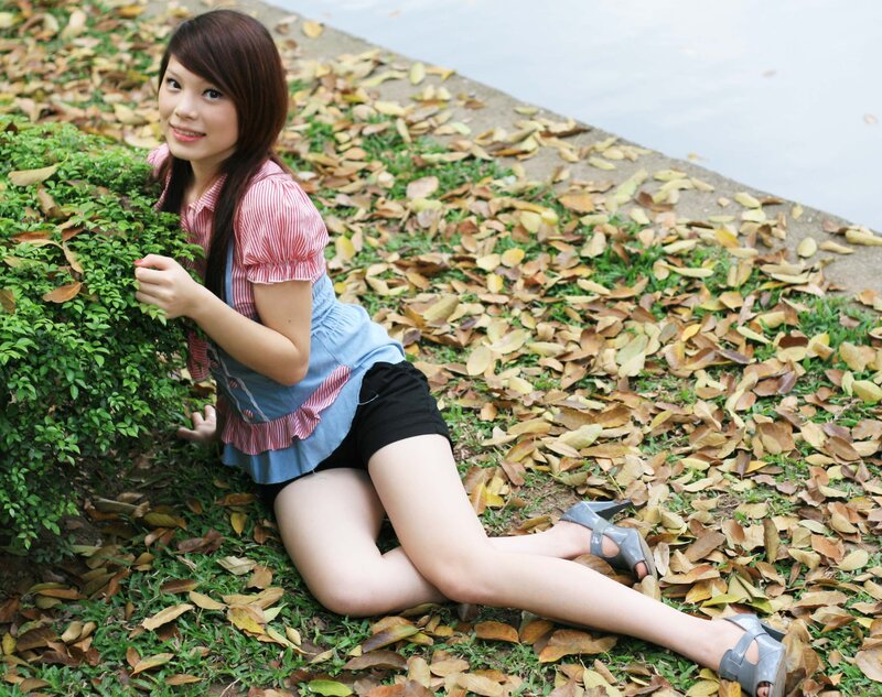 Woman sitting on grass with leaves