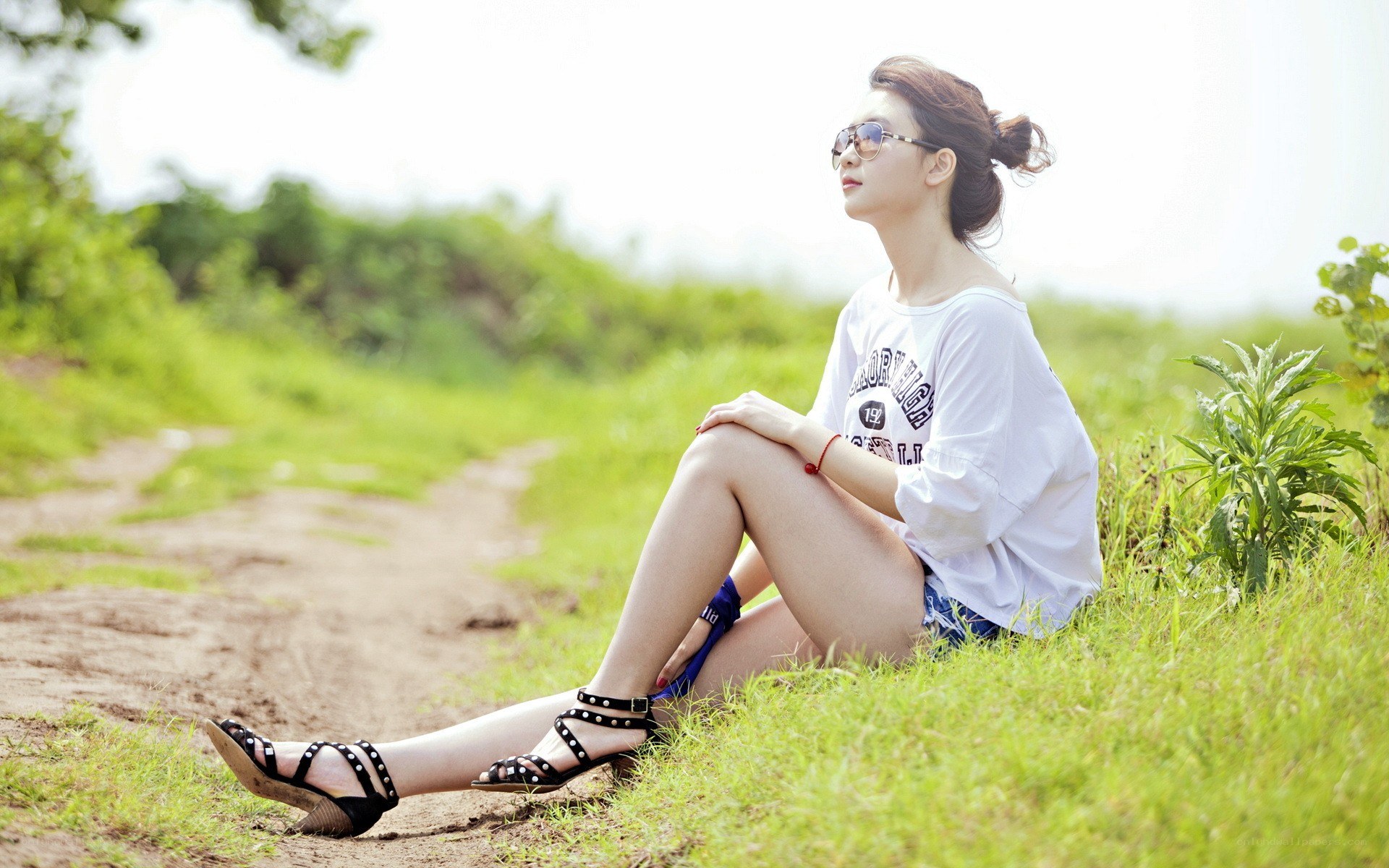woman sitting on grassy path