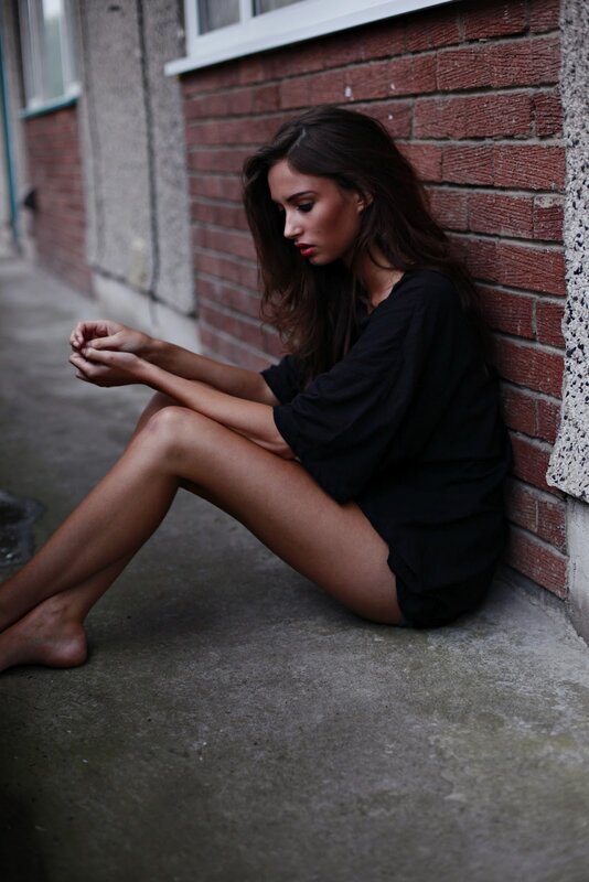 Woman Sitting on Ground — Black, Melancholic, Photograph, Brick Wall