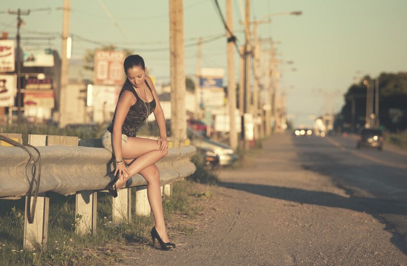 Woman Sitting on Guardrail — Brown