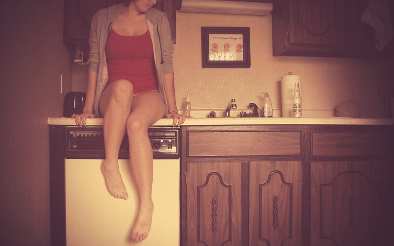 woman sitting on kitchen counter