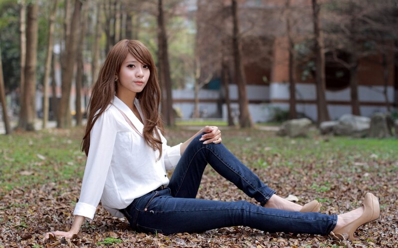 woman sitting on leaves in park