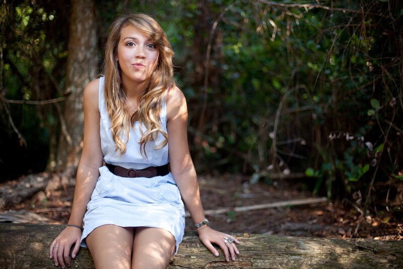 woman sitting on log in forest