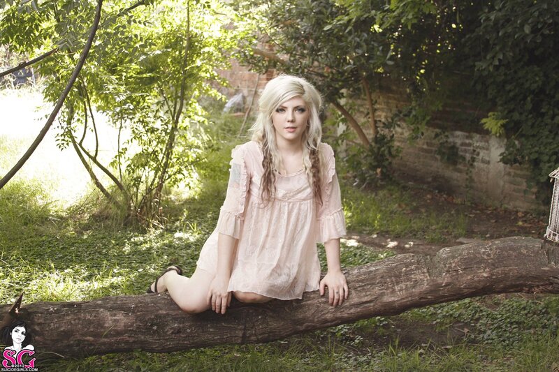woman sitting on log in garden