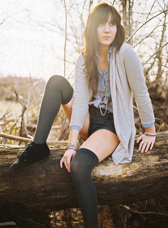 woman sitting on log outdoors