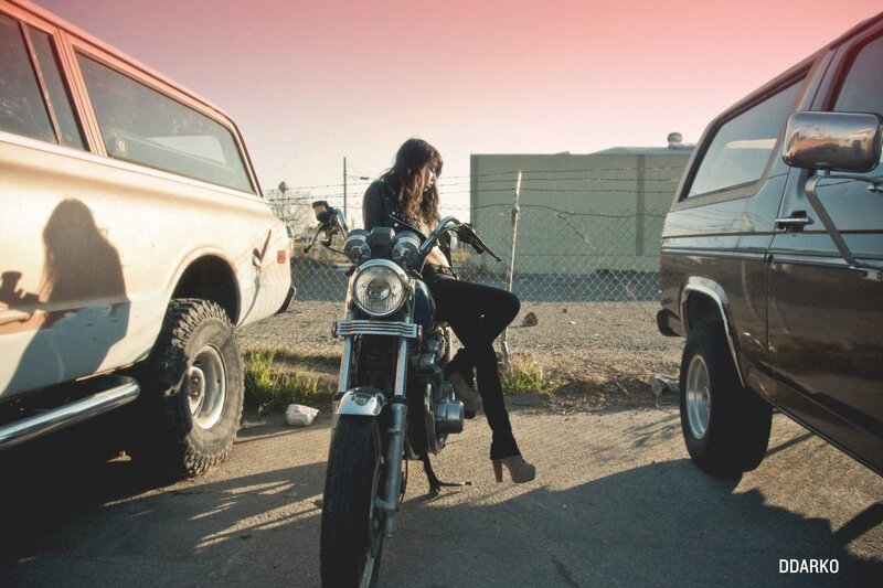 woman sitting on motorcycle between trucks