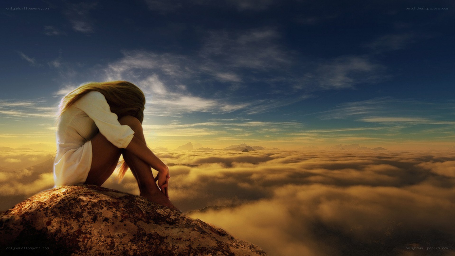 woman sitting on mountain peak
