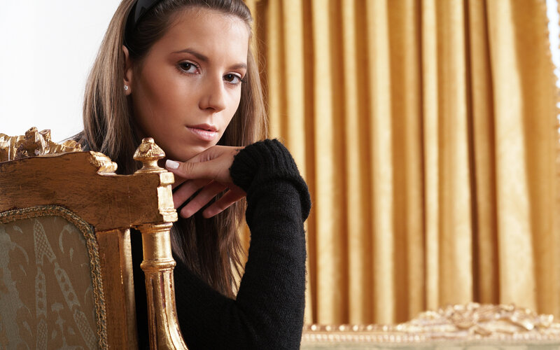 woman sitting on ornate chair