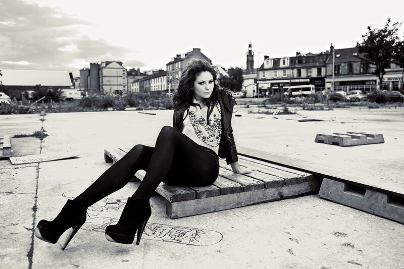 woman sitting on pallet in urban setting