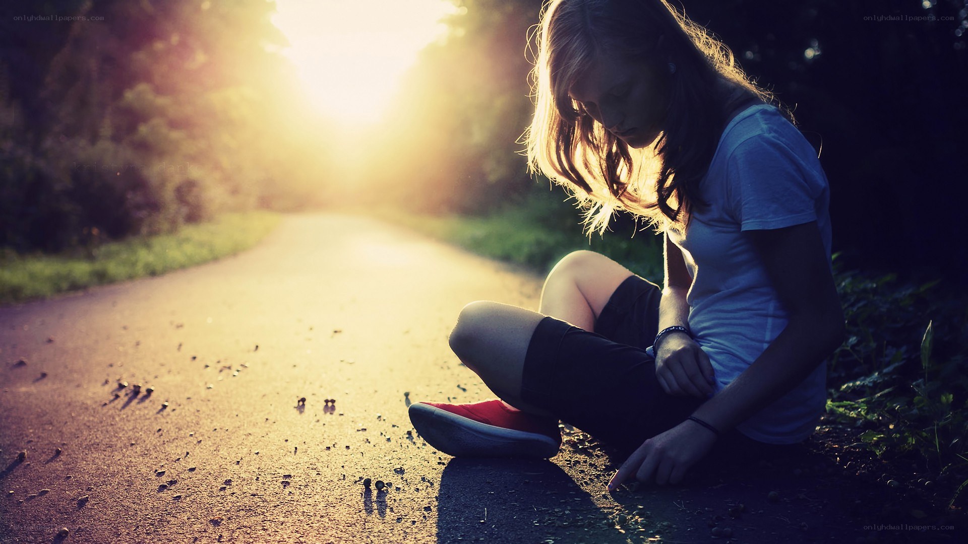 woman sitting on path at sunset