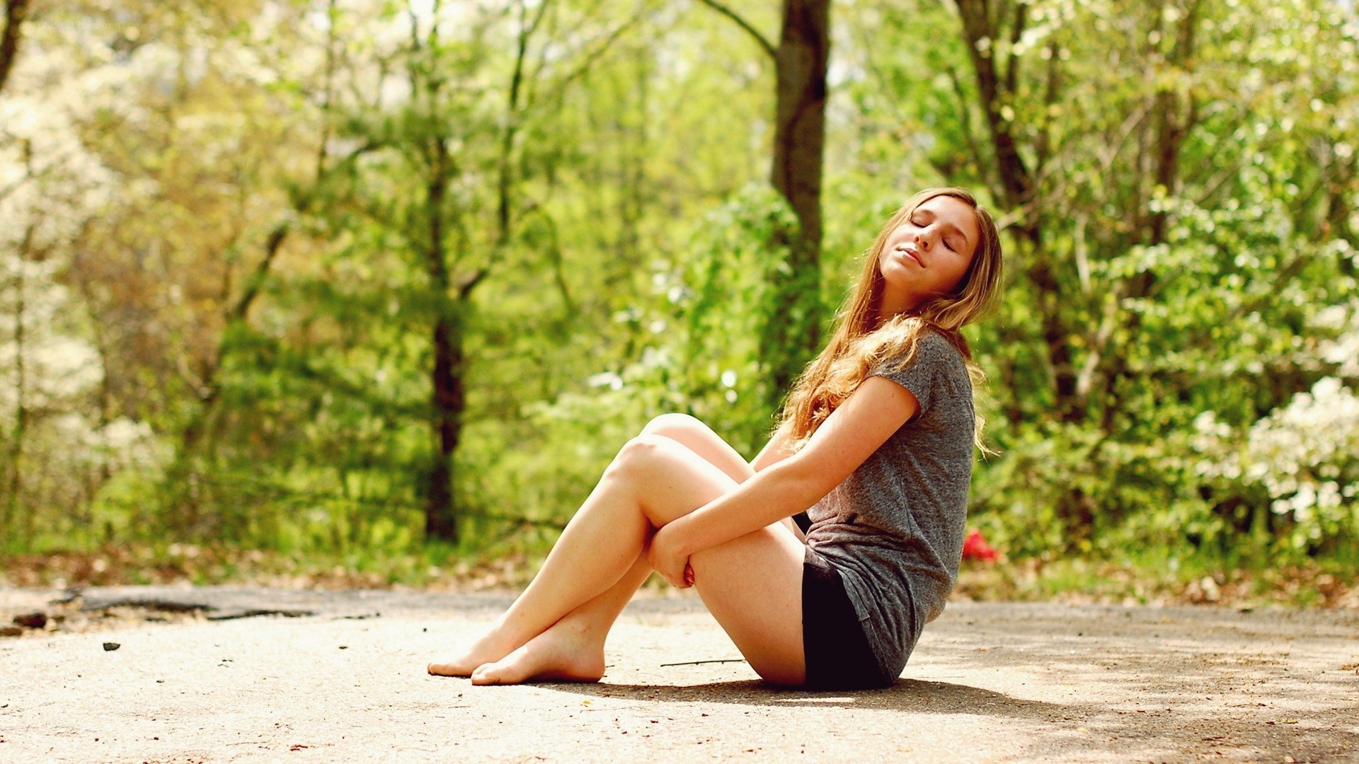 woman sitting on path in forest