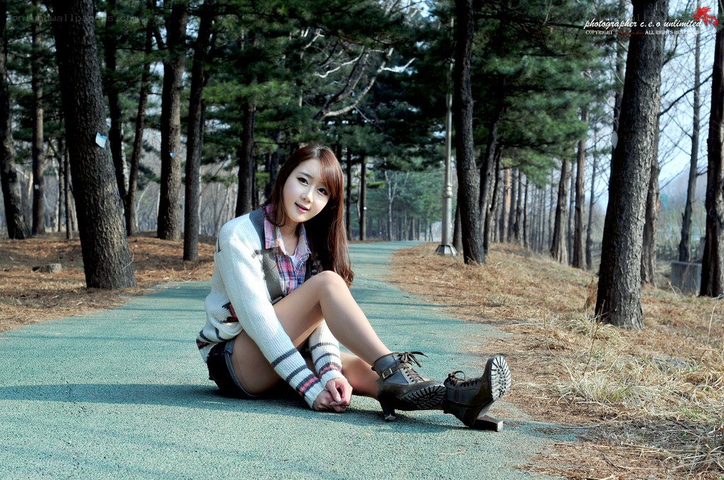 woman sitting on path in forest