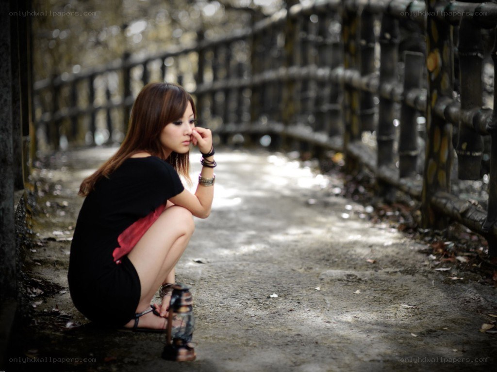 woman sitting on path with lantern