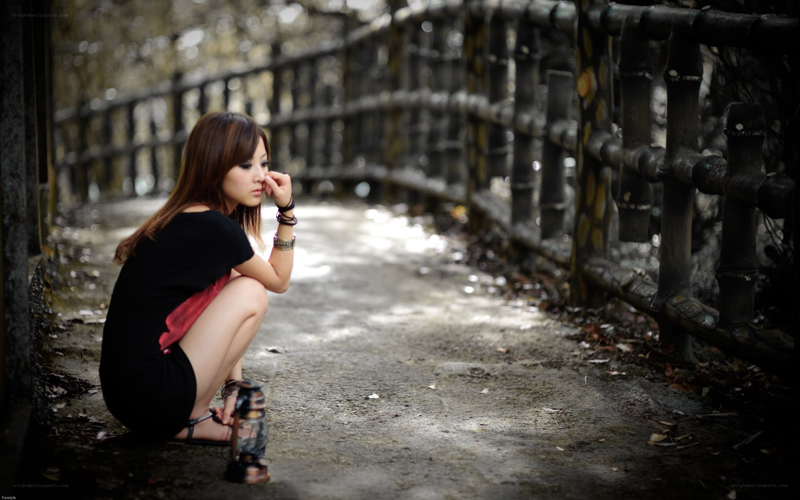 woman sitting on path with lantern