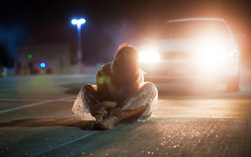 woman sitting on pavement at night