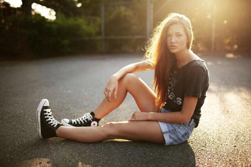woman sitting on pavement at sunset