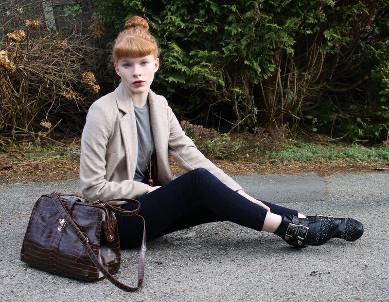 woman sitting on pavement with bag
