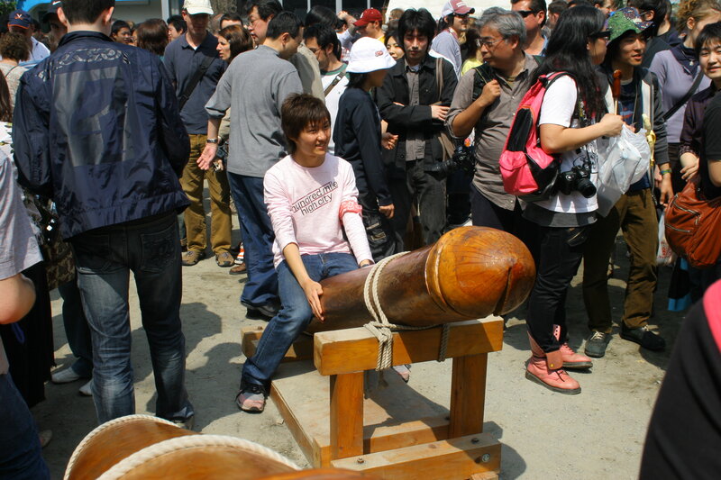 Woman sitting on phallic sculpture