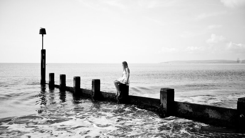 Woman Sitting on Pier — Black, Serene, Afternoon, Photograph