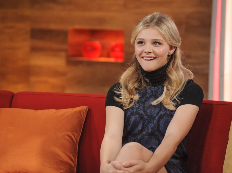 woman sitting on red couch