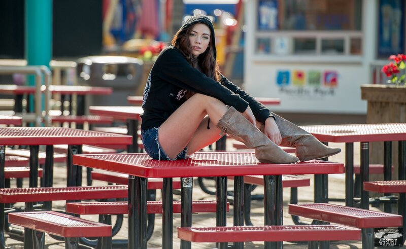 woman sitting on red picnic table