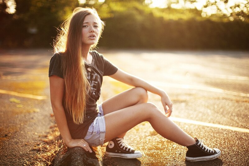 woman sitting on road at sunset