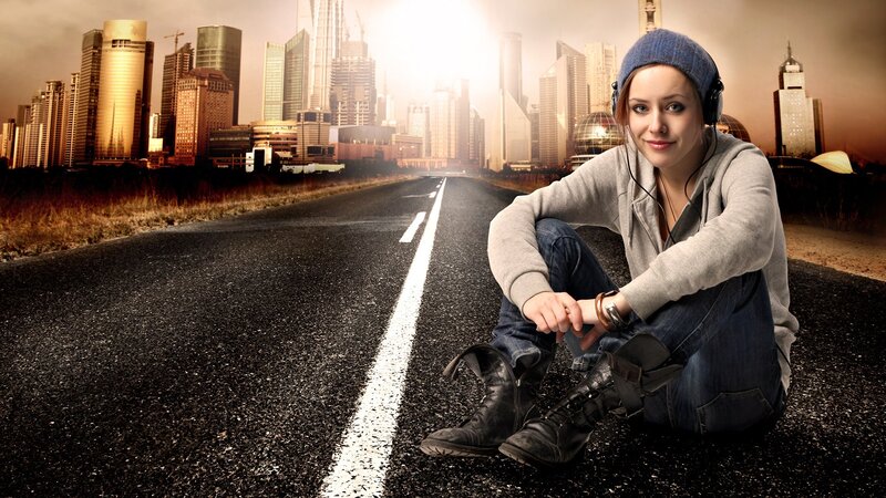 woman sitting on road with city
