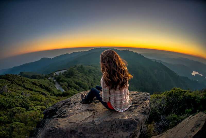 Woman Sitting on Rock — Green, Serene, Sunset, Photograph
