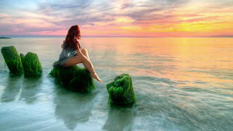 Woman Sitting on Rock — Orange