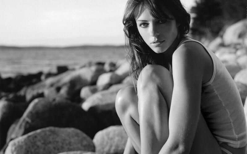 Woman Sitting on Rocks — Black, Contemplative, Sunset