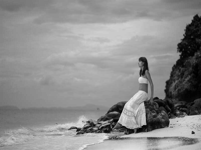 Woman Sitting on Rocks — Black, Serene