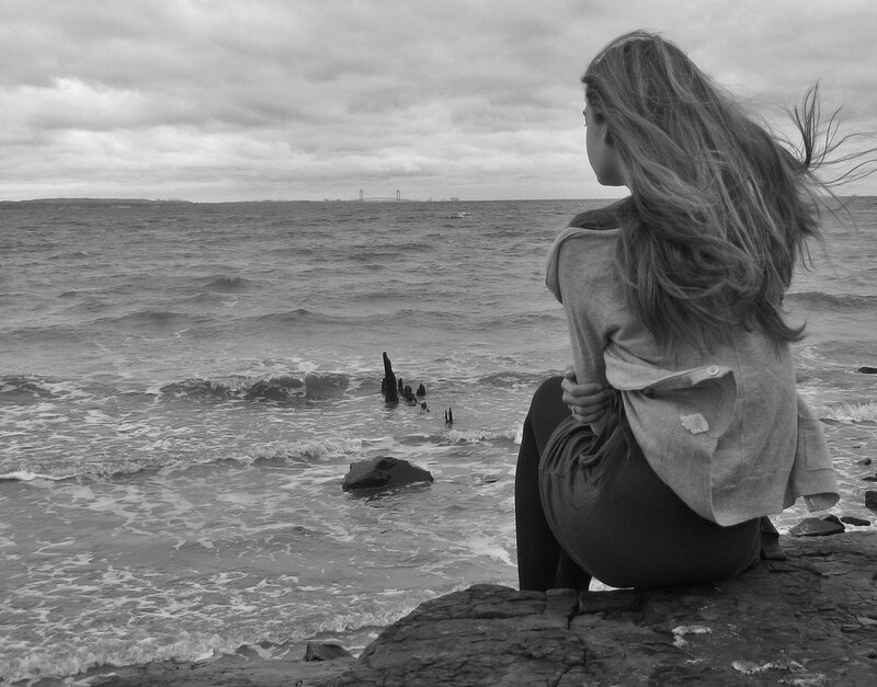 Woman Sitting on Rocks — Black, Somber
