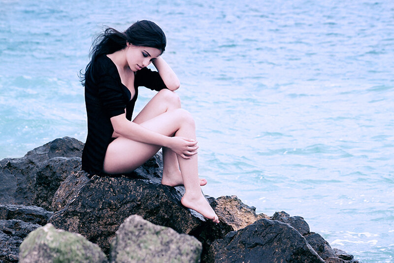 Woman Sitting on Rocks — Blue