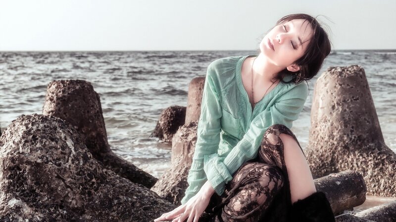 Woman Sitting on Rocks — Green, Serene, Afternoon, Photograph
