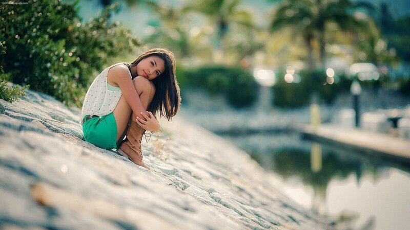 Woman Sitting on Rocks — Green