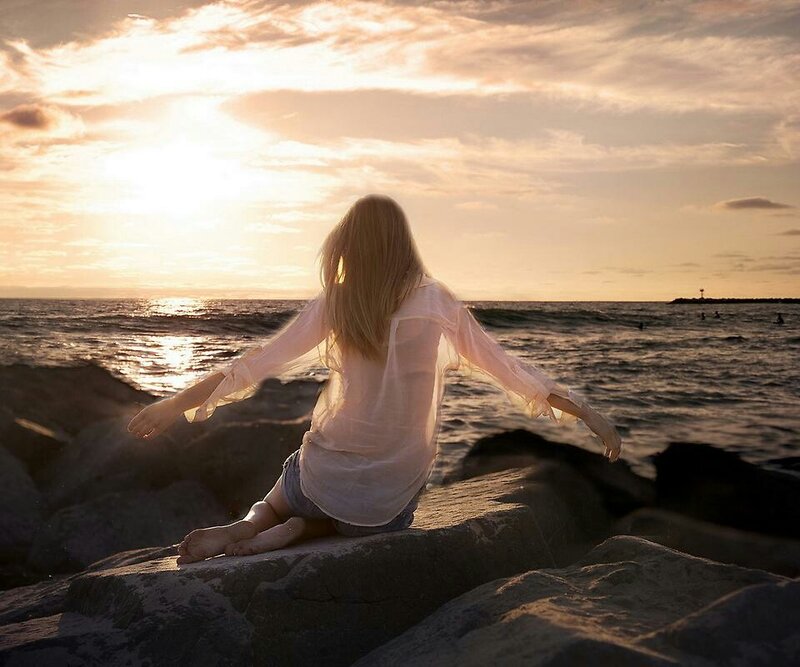 Woman Sitting on Rocks — Orange, Serene, Sunset, Photograph, Ocean