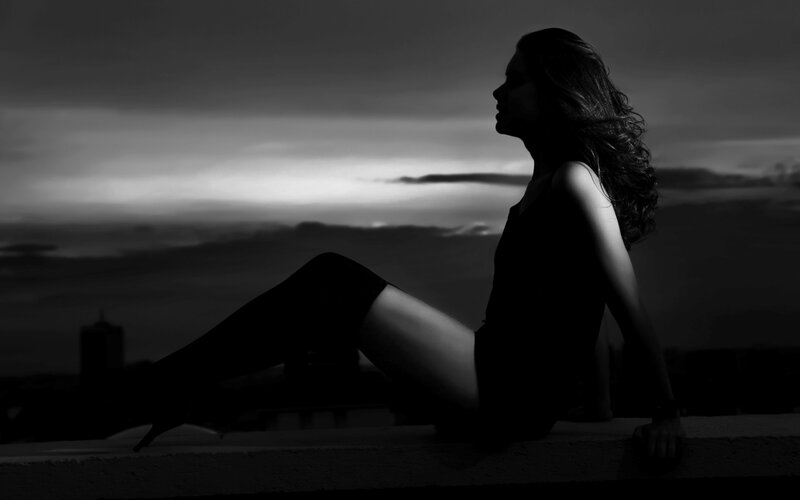 woman sitting on rooftop at dusk