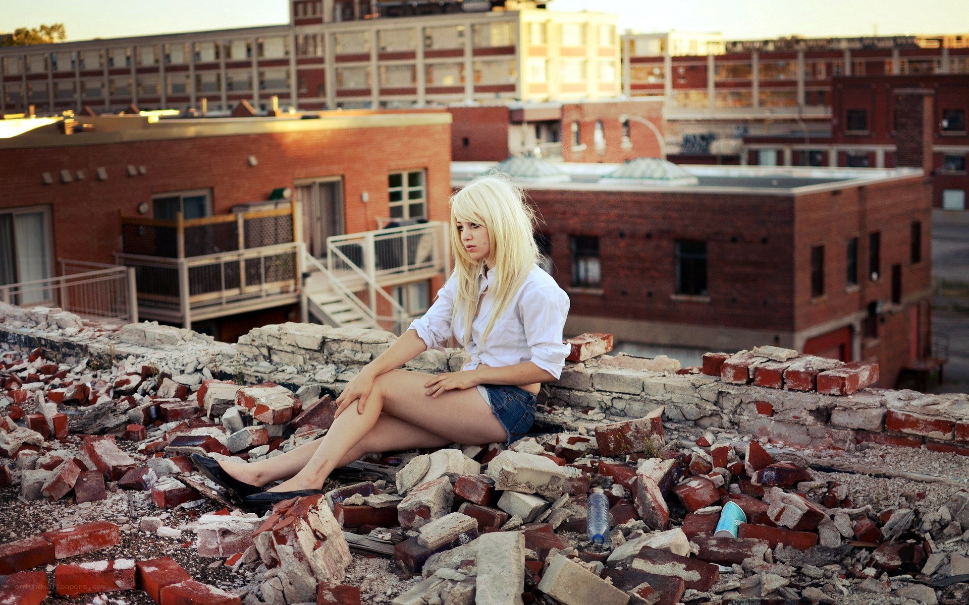 woman sitting on rubble rooftop